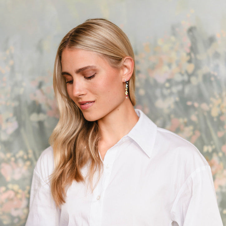 Woman wearing a white shirt against a blurred floral background