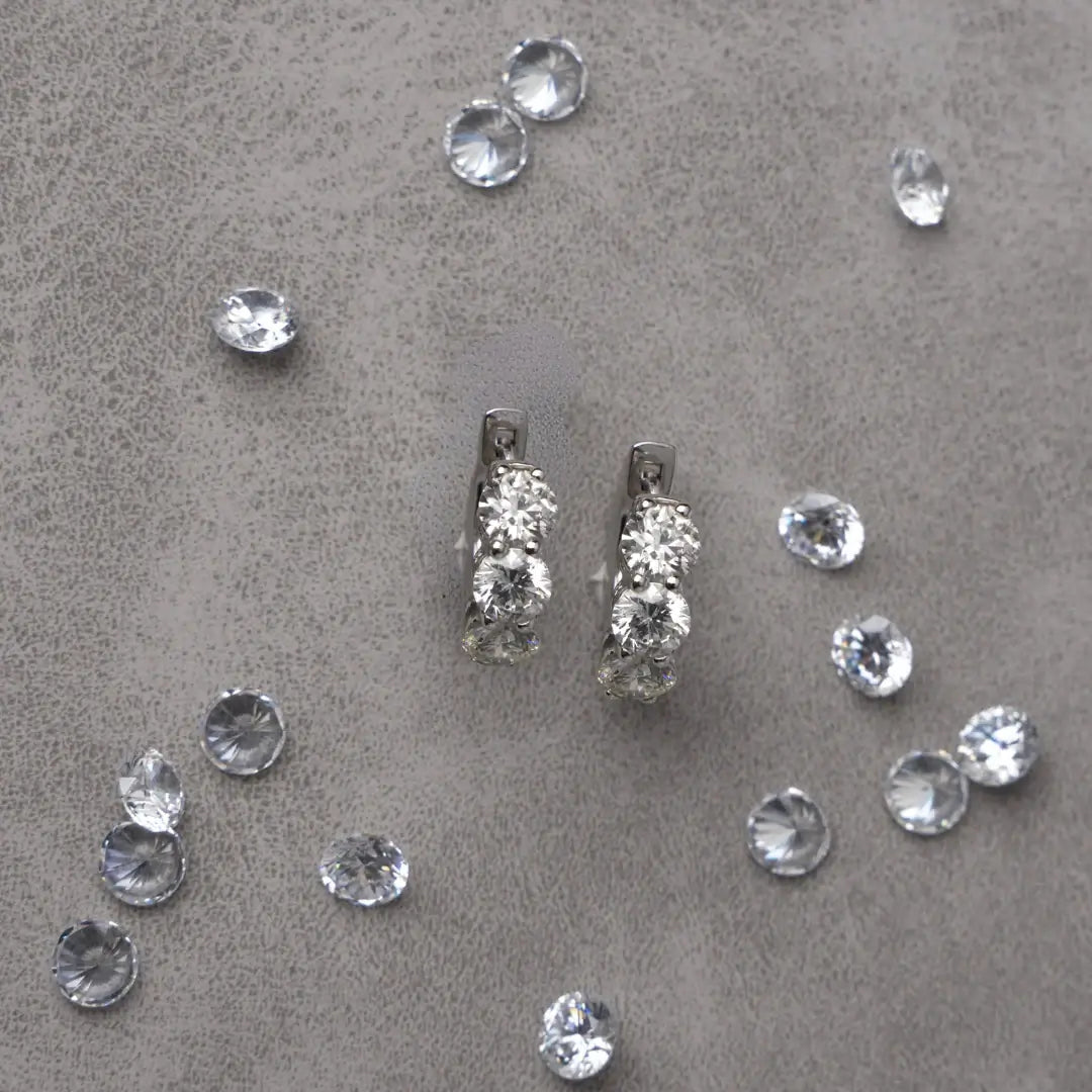 Pair of 3 stone diamond huggie gold earrings. 3-Stone Diamond Huggies. Solid gold and natural diamonds. Jewelry Dallas.