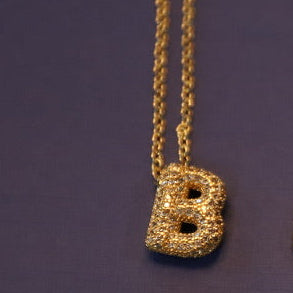 Necklace with a 'B' pendant on a purple background. Diamond Letter Pendant.