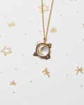 Necklace with a moon-phase pendant on a white background with gold stars