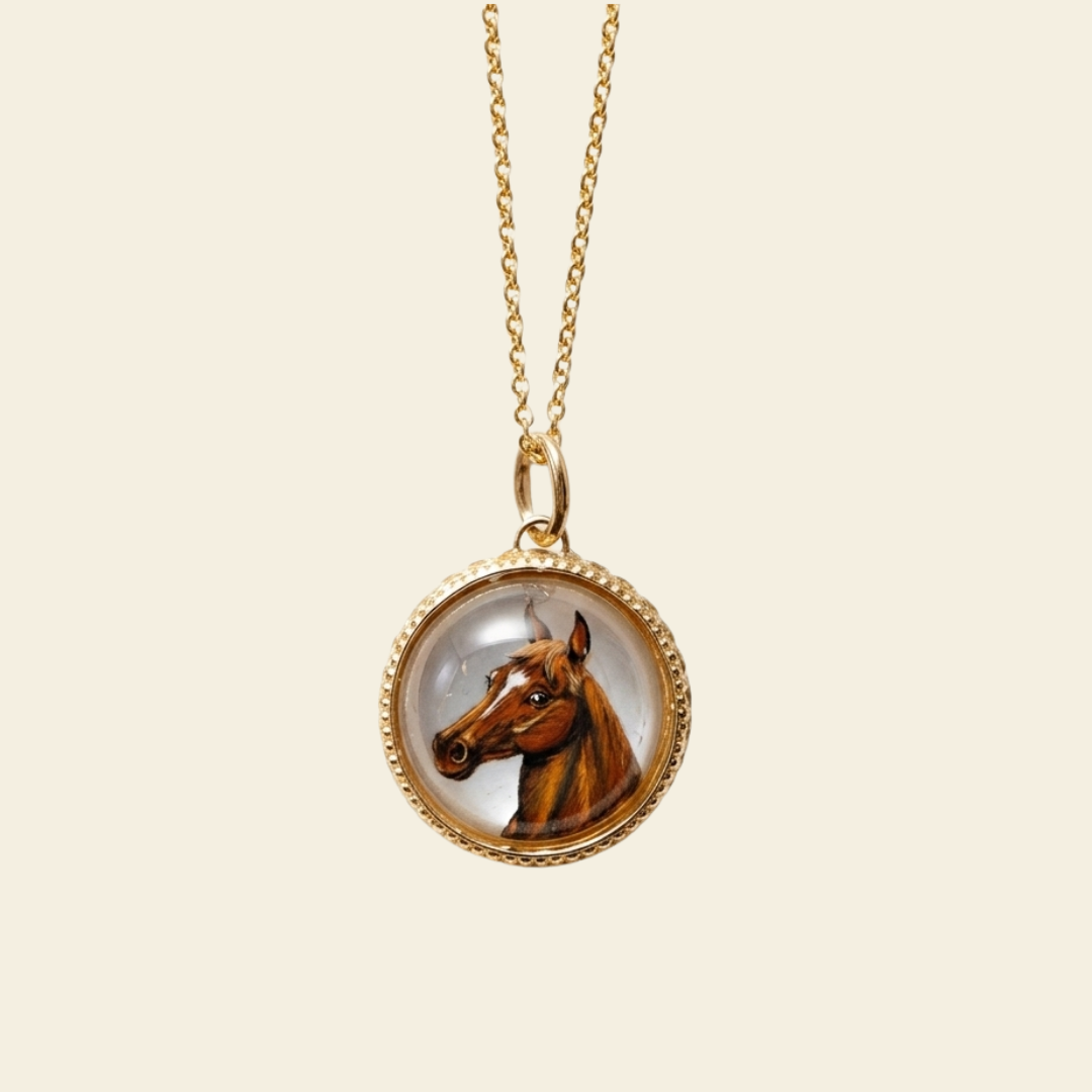Gold necklace with a pendant featuring an image of a horse on a beige background