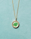 Necklace with a clover pendant on a light blue background