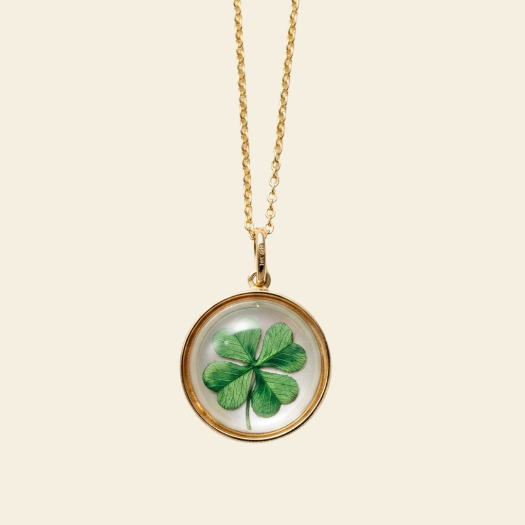 Gold necklace with a clover pendant on a beige background