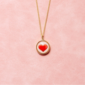 Necklace with a red heart pendant on a pink background