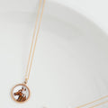 A delicate rose gold chain necklace with a circular pendant featuring a custom photo of a horse, displayed on a clean white background.