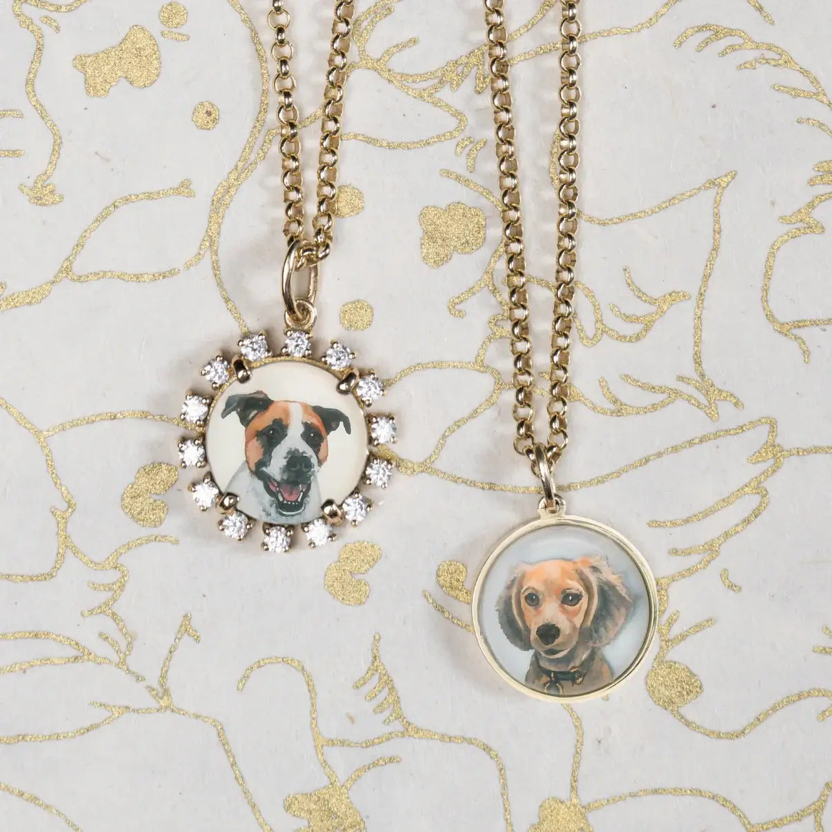 Two necklaces with circular pendants featuring dog portraits on a decorative background. Custom Pet Portrait. Hand-carved in Germany and painted in reverse intaglio on rock crystal, each charm is backed with luminous mother-of-pearl and set in your choice of 18K yellow, rose, or white gold. Jewelry Dallas.