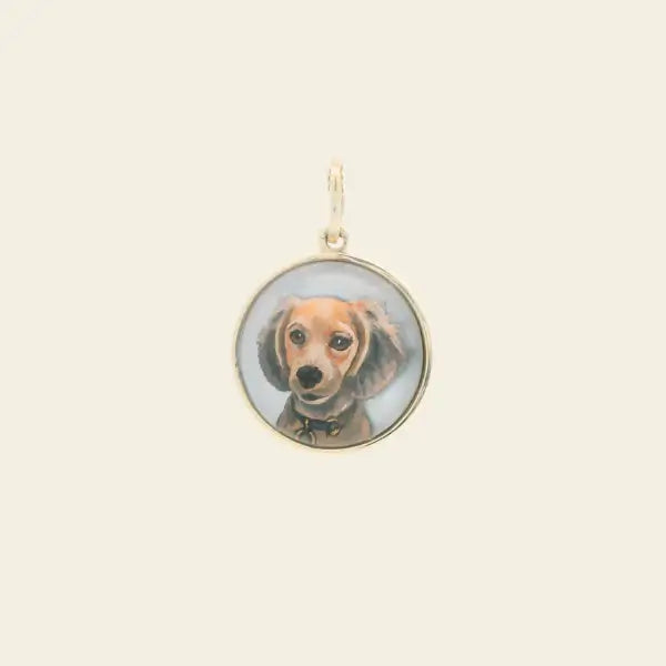 Gold pendant with a small circular photo of a dog on a beige background. Custom Pet Portrait. Hand-carved in Germany and painted in reverse intaglio on rock crystal, each charm is backed with luminous mother-of-pearl and set in your choice of 18K yellow, rose, or white gold. Jewelry Dallas.