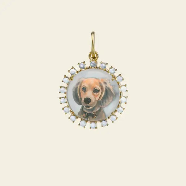 Gold pendant with pearls featuring a photo of a dog inside on a beige background. Custom Pet Portrait. Hand-carved in Germany and painted in reverse intaglio on rock crystal, each charm is backed with luminous mother-of-pearl and set in your choice of 18K yellow, rose, or white gold. Jewelry Dallas.