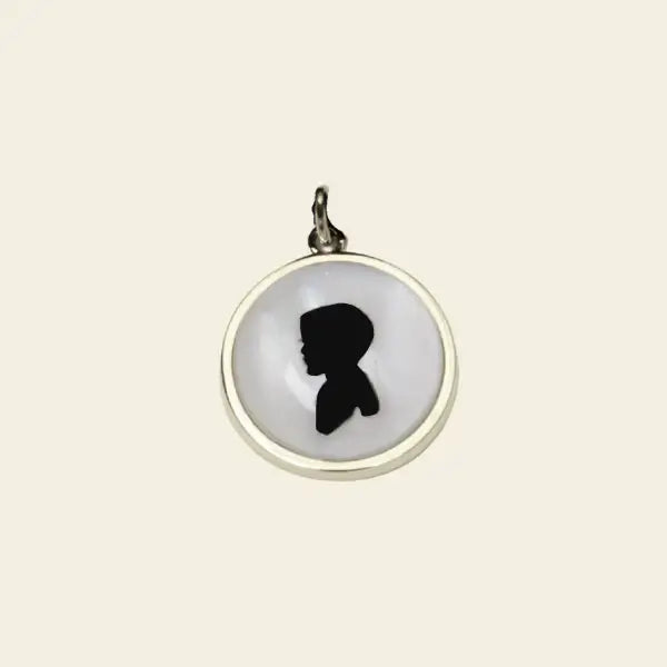 Custom silhouette pendant in gold with mother of pearl backing. Custom Silhouette Pendant. Materials: Solid 14K Yellow Gold with Crystal and a Mother of Pearl backing. Jewelry Dallas.