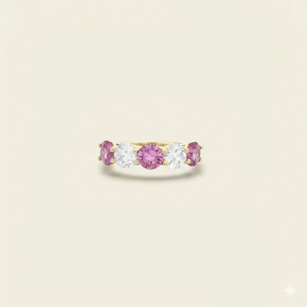 Gold ring with pink sapphires and diamonds on a beige background. Five Stone Pink Sapphire and Diamond Ring. # of Diamonds:2.5 Carat Weight:1.60 carats Shape:RoundColor:G-HClarity:SI1-SI2Cut:Excellent # of Sapphires:3Carat Weight:2.40 carats Shape:RoundColor:PinkClarity:Eye CleanCut:Excellent. Jewelry Dallas.
