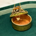 Green jewelry box with a gold necklace on a green background. Flower Power. Length: 16