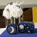 Blue velvet travel jewelry box with embroidered moon and stars next to its mini version. Fly Me to the Moon Navy Blue Velvet Embroidered Travel Jewelry Box. Jewelry Dallas.
