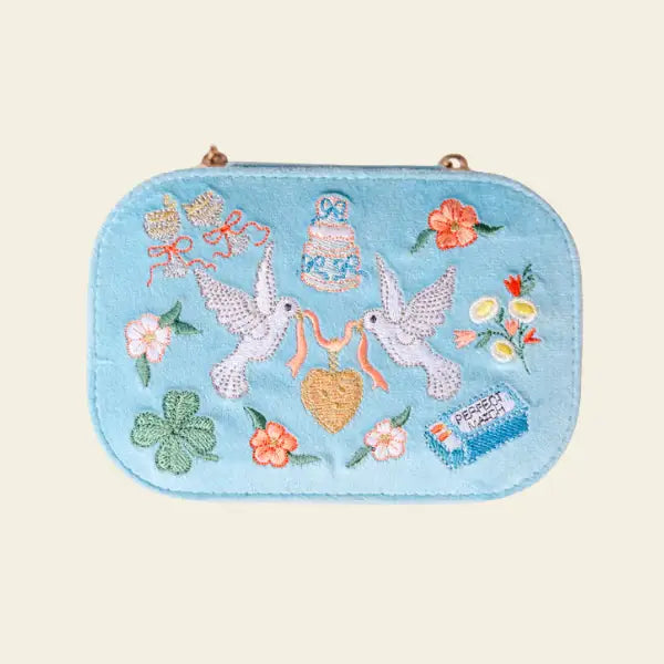 Embroidered travel jewelry box with birds, flowers, and a heart on a light blue velvet background, perfect for brides. Forever After Blue Velvet Embroidered Travel Jewelry Box. Jewelry Dallas.