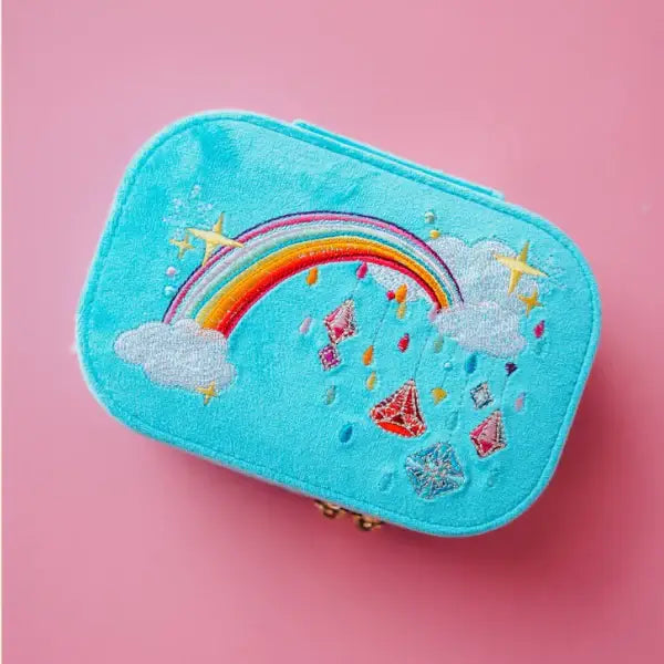 Blue velvet travel jewelry box with rainbow and cloud design on a beige background. Jewels with Jules Velvet Embroidered Travel Jewelry Box. Jewelry Dallas.