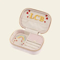 Pink velvet travel jewelry base with 'LCB' initials and embroidered rainbow design on a beige background.  Love in the Air Light Pink Velvet Embroidered Travel Jewelry Box. Jewelry Dallas.