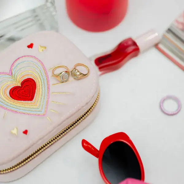 Heart embroidered velvet travel jewelry box with rings on a white surface.  Love in the Air Light Pink Velvet Embroidered Travel Jewelry Box. Jewelry Dallas.