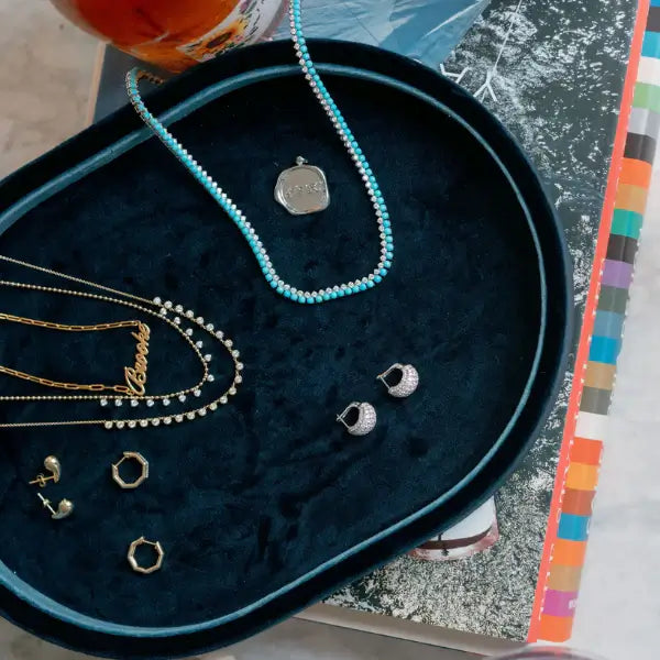 Navy blue velvet jewelry tray with 'AES' initials on a beige background. Navy Velvet Jewelry Tray. Jewelry Dallas.