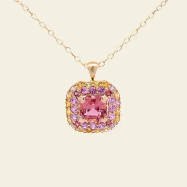 Gold necklace with a pink tourmaline gemstone pendant on a beige background. One-of-a-Kind Pendant with Pink Tourmaline. The pendant is set in solid 14K gold with a blend of polished and subtly textured details that add richness and character. It hangs from a 3.2mm rolo chain. Jewelry Dallas.