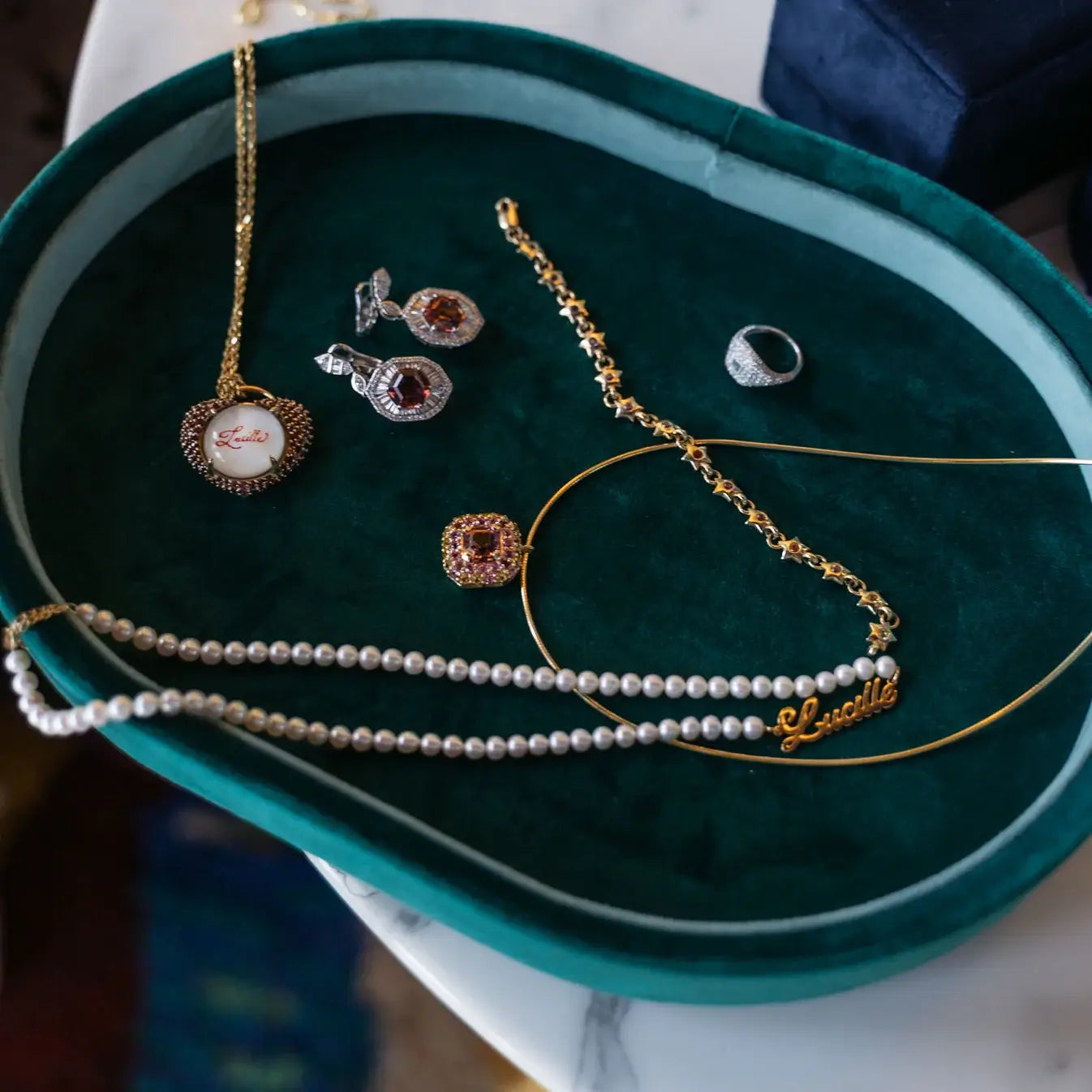 Jewelry, including necklaces and earrings on a green velvet jewelry tray. One-of-a-Kind Pendant with Pink Tourmaline. The pendant is set in solid 14K gold with a blend of polished and subtly textured details that add richness and character. It hangs from a 3.2mm rolo chain. Jewelry Dallas.