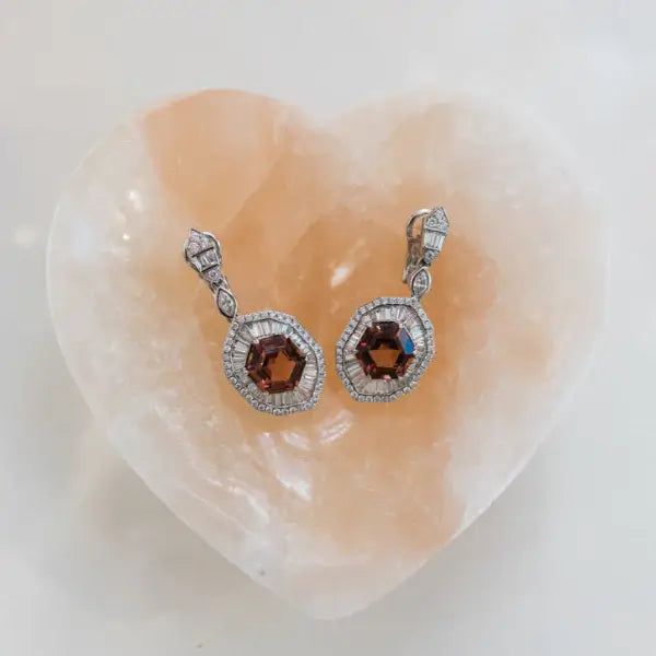Pair of earrings with pink tourmalines and diamonds on a heart-shaped gemstone. Pink Tourmaline Hexagon Drop Earrings with Diamonds. 9.10 carats of vibrant hexagon-cut pink tourmalines, accented by 2.84 carats of brilliant diamonds, set in 18k white gold. Jewelry Dallas.