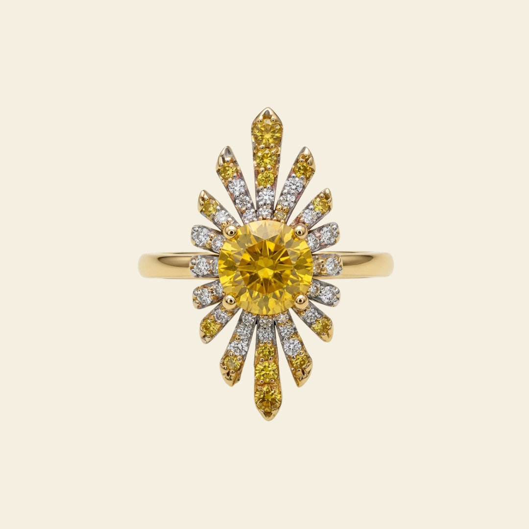 A yellow gold sunburst ring featuring a large round yellow center stone and smaller yellow and clear accent stones, set against a solid cream background.