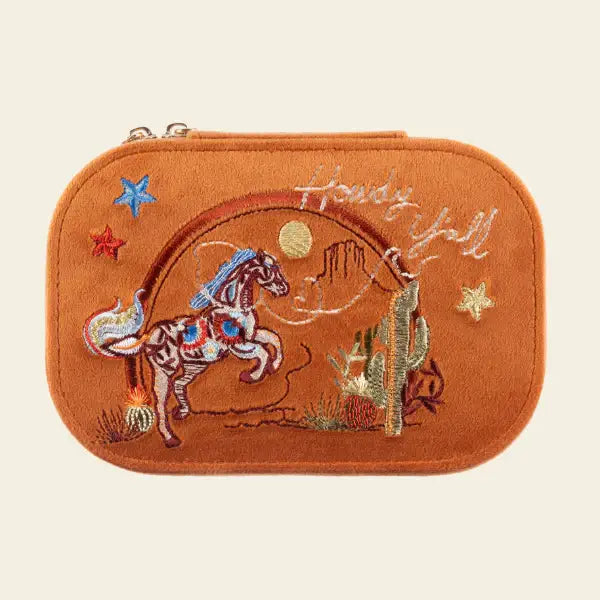 Embroidered Texas velvet orange travel jewelry box with horse design on a beige background. Spirit of Texas Burnt Orange Velvet Embroidered Travel Jewelry Box. Jewelry Dallas.