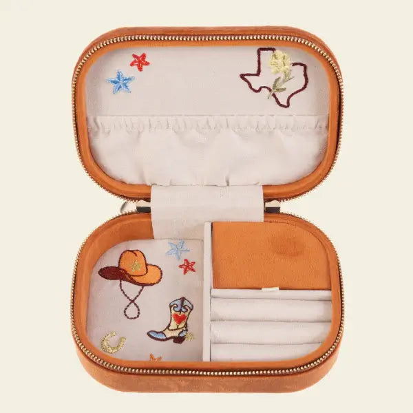 Embroidered Texas velvet orange travel jewelry box with horse design on a beige background. Spirit of Texas Burnt Orange Velvet Embroidered Travel Jewelry Box. Jewelry Dallas.