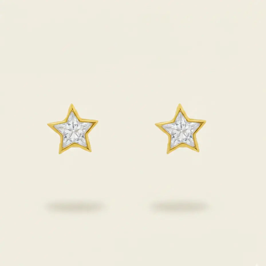 Star-shaped earrings with a gold setting and diamonds on a beige background. Star Studs. Materials: 18K Yellow Gold and Hand-Cut Natural Diamonds totaling 0.74 carats. Jewelry Dallas.