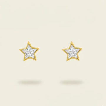 Star-shaped earrings with a gold setting and diamonds on a beige background. Star Studs. Materials: 18K Yellow Gold and Hand-Cut Natural Diamonds totaling 0.74 carats. Jewelry Dallas.
