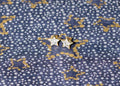 Star-shaped diamond earrings on a patterned background. Star Studs. Materials: 18K Yellow Gold and Hand-Cut Natural Diamonds totaling 0.74 carats. Jewelry Dallas.