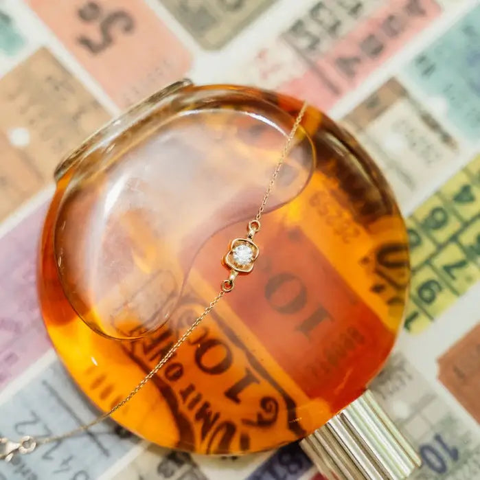 Gold bracelet with a diamond wax seal on a beige background. Wax Seal Bracelet. Length and Layering: 6" Bracelet with 1" Extension
Available in 14K Yellow Gold
Details: Wax seal charm set with 0.40 carat round natural diamond. Jewelry Dallas.
