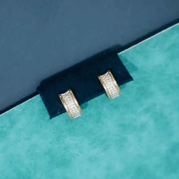 Gold hoop earrings with diamond accents on a beige background. Wide Diamond Huggies. Metal Type: 14k Yellow/white Gold Total Diamond Weight:0.60 ct
Average Diamond Clarity: SI or higher
Average Diamond Color: Near Colorless
Gemstone: Natural Diamond. Jewelry Dallas.